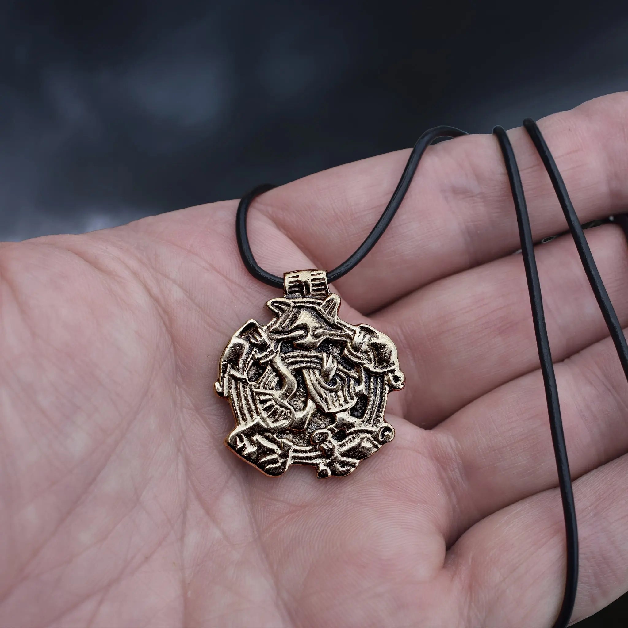 Solid Bronze Replica Viking Gripping Beats Pendant from 10th century Sweden on Leather Cord Wrapped Around Hand