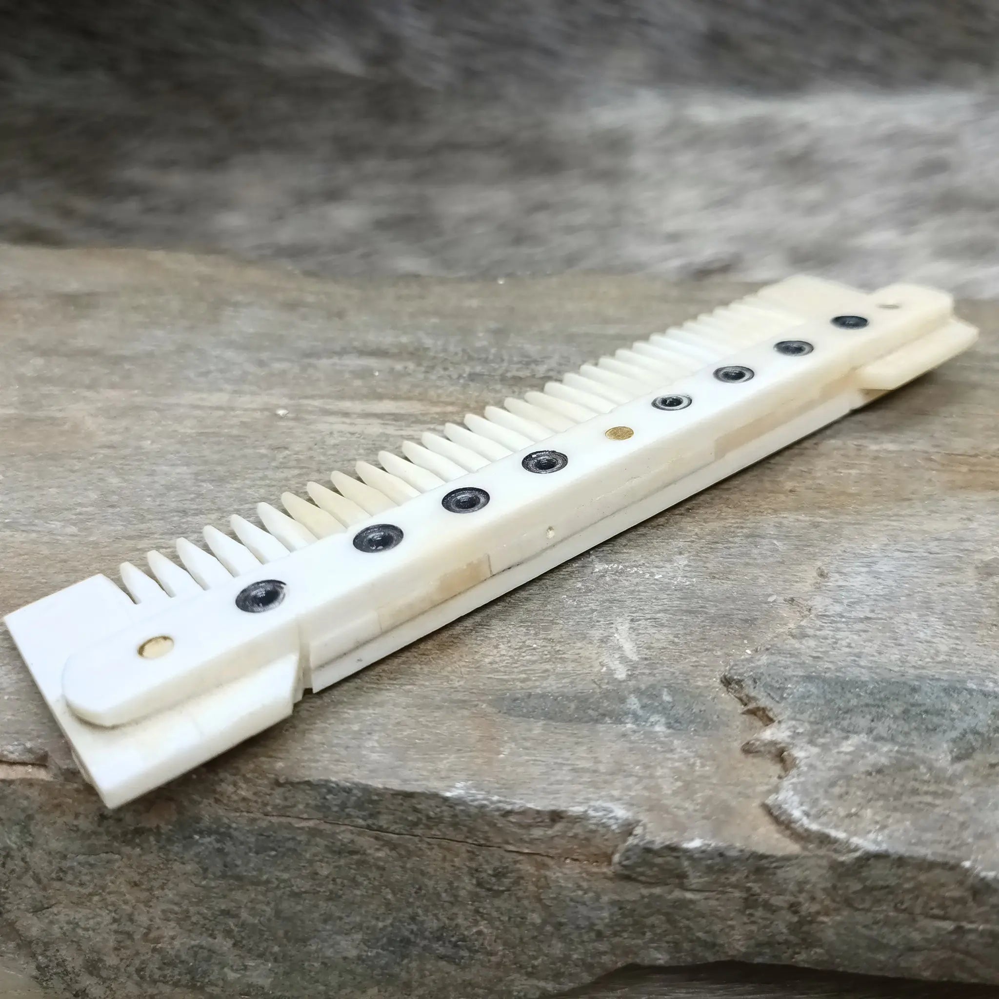 Medium Decorated Bone Viking Comb on Rock - Back View