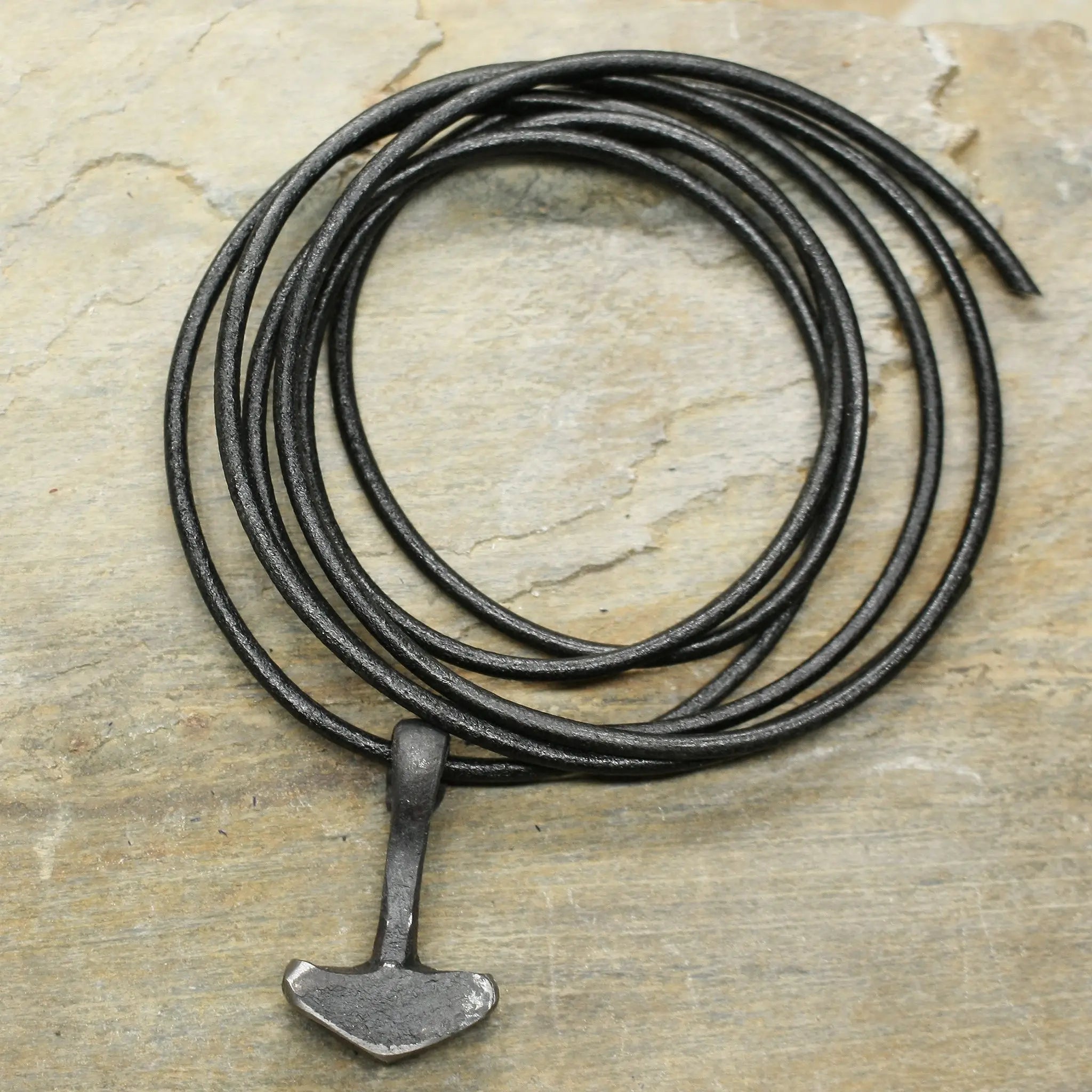 Hand Forged Replica Iron Thors Hammer Pendant on 2mm Black Thong on Rock