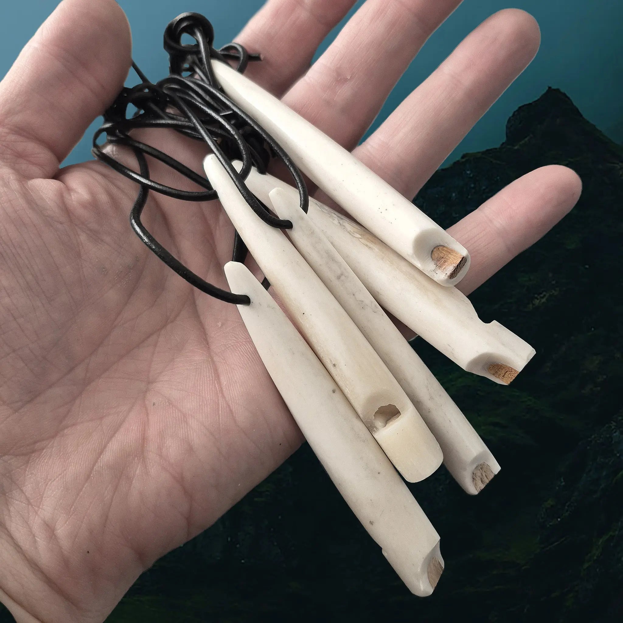 Handmade Replica Viking Age Bone Whistles with Wooden Block on Leather Cords on Hand
