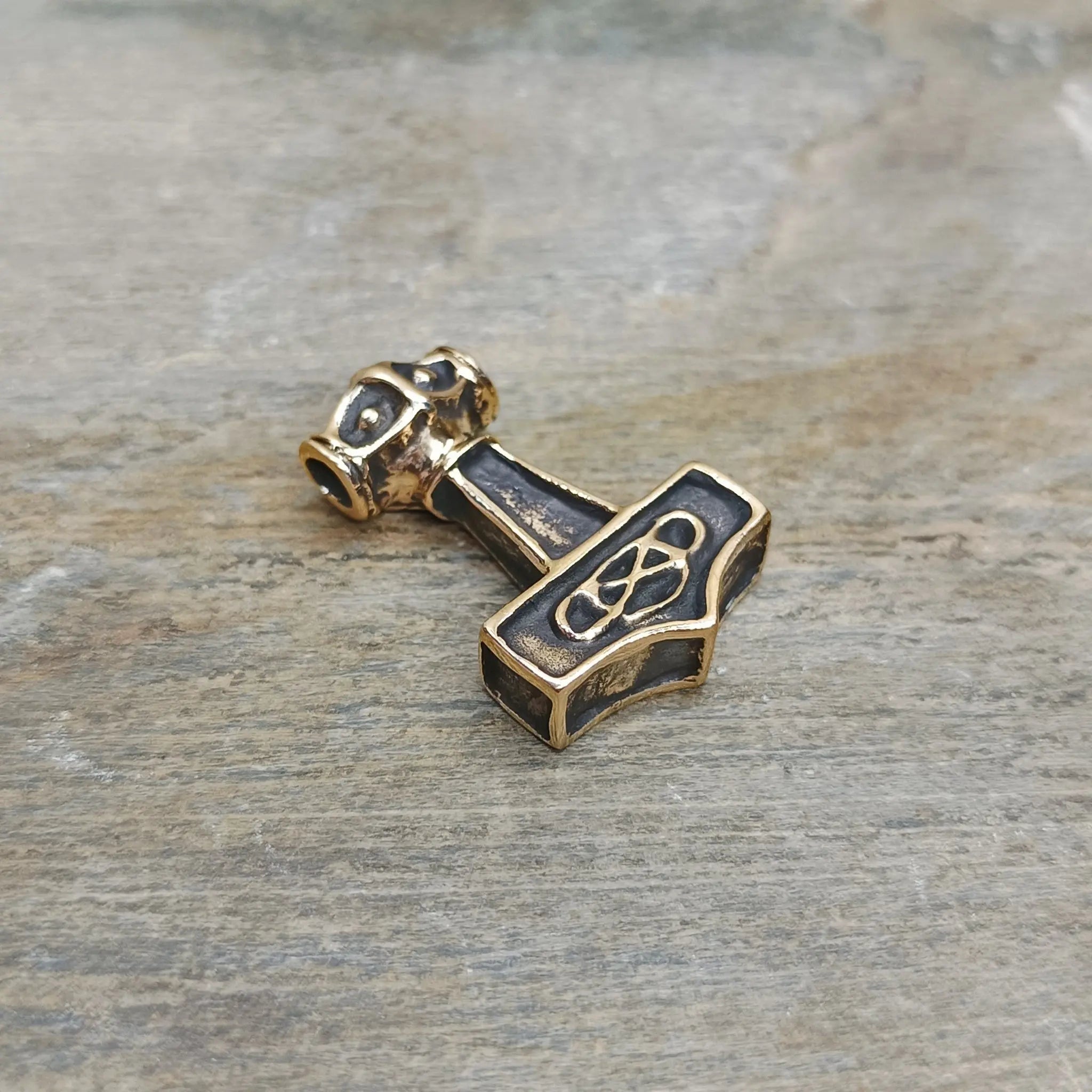 Small Bronze Thunder Thors Hammer Pendant on Rock - Front Angle View